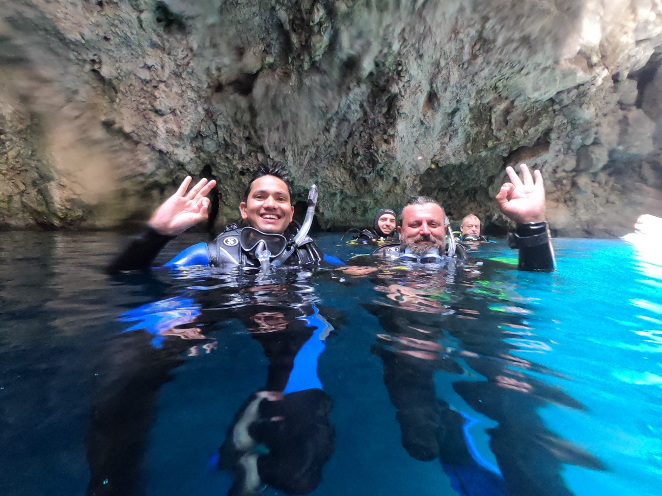 Mayur surfacing with other divers inside a sea cave